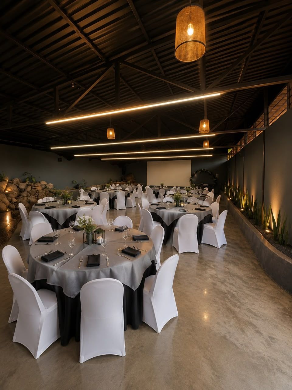 Salón montado en mesas redondas con mantelería negra y gris